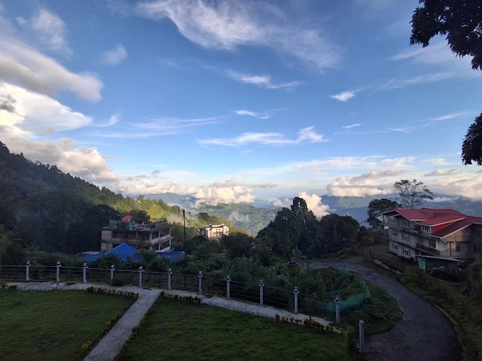 A wide daytime view over the garden and fencing toward the hills under an open sky